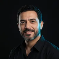 Kevin L., bearded, smiling, in a black shirt