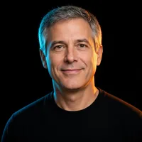 Ryan P., grey-haired, smiling, in a black T-shirt